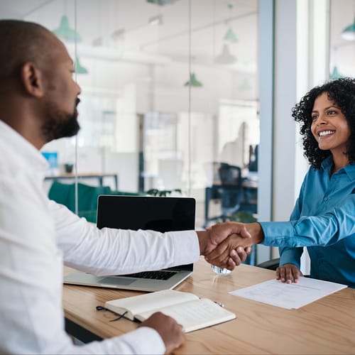 Smiling,African,American,Manager,Sitting,At,His,Desk,In,An